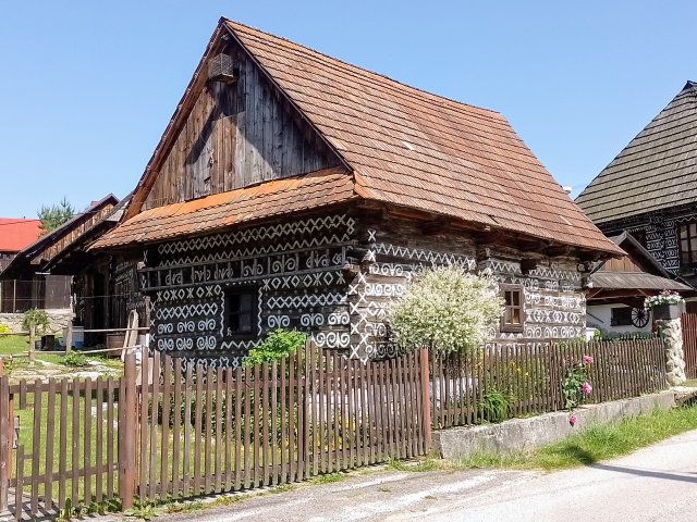 Fast 140 bemalte Holzhäuser, verziert mit kunstvollen weißen Ornamenten, stehen hier dicht an dicht.